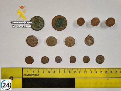 Asombrado un hombre en el establecimiento arqueológico de Romangordo con monedas y piezas viejas en su turismo